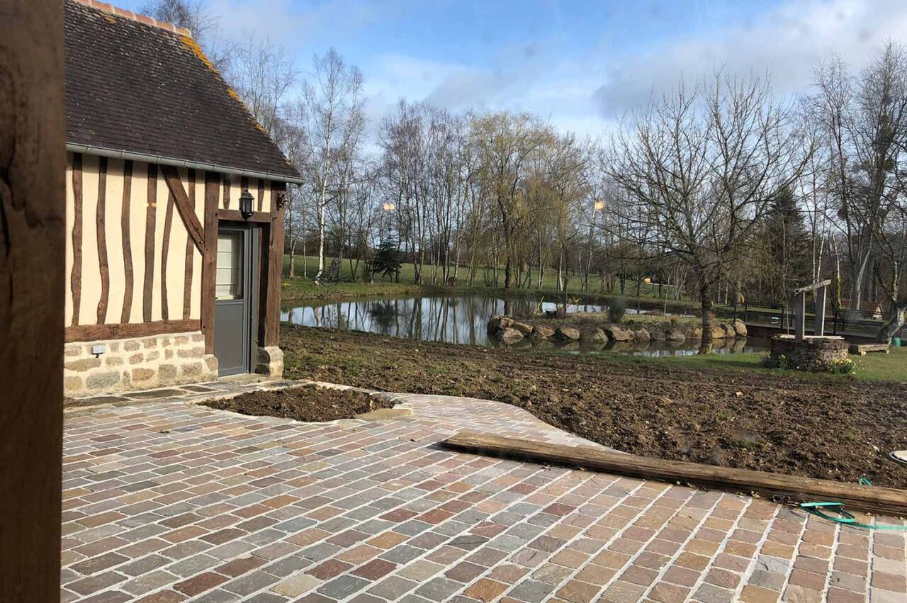 View of the terrace in front of the pool house looking out at the lake.