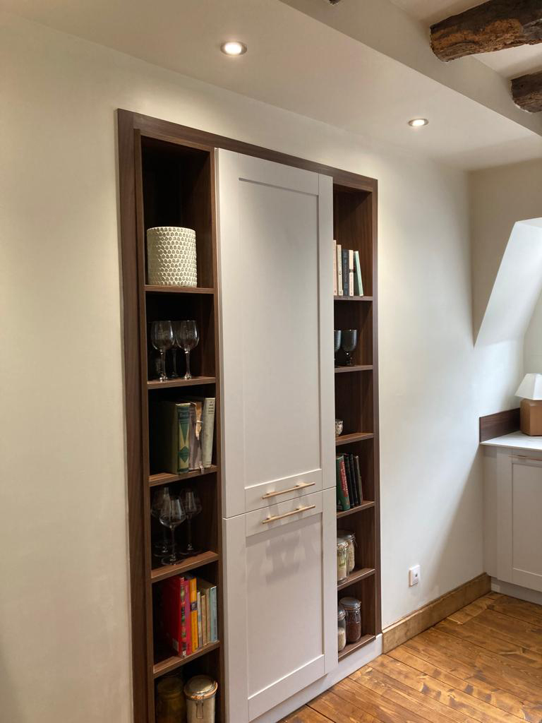 Bespoke design cupboard, with small bookshelfs on both sides. Built into the wall.