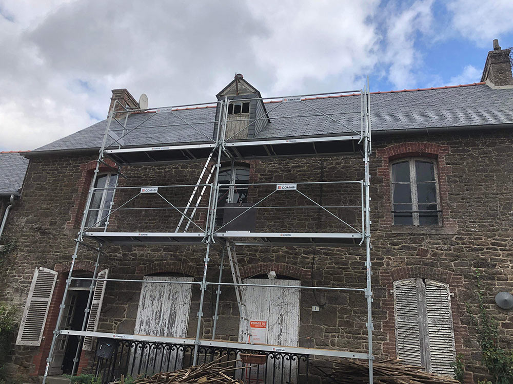 View of the front of the house with the scaffolding in front, new roof has already been installed.