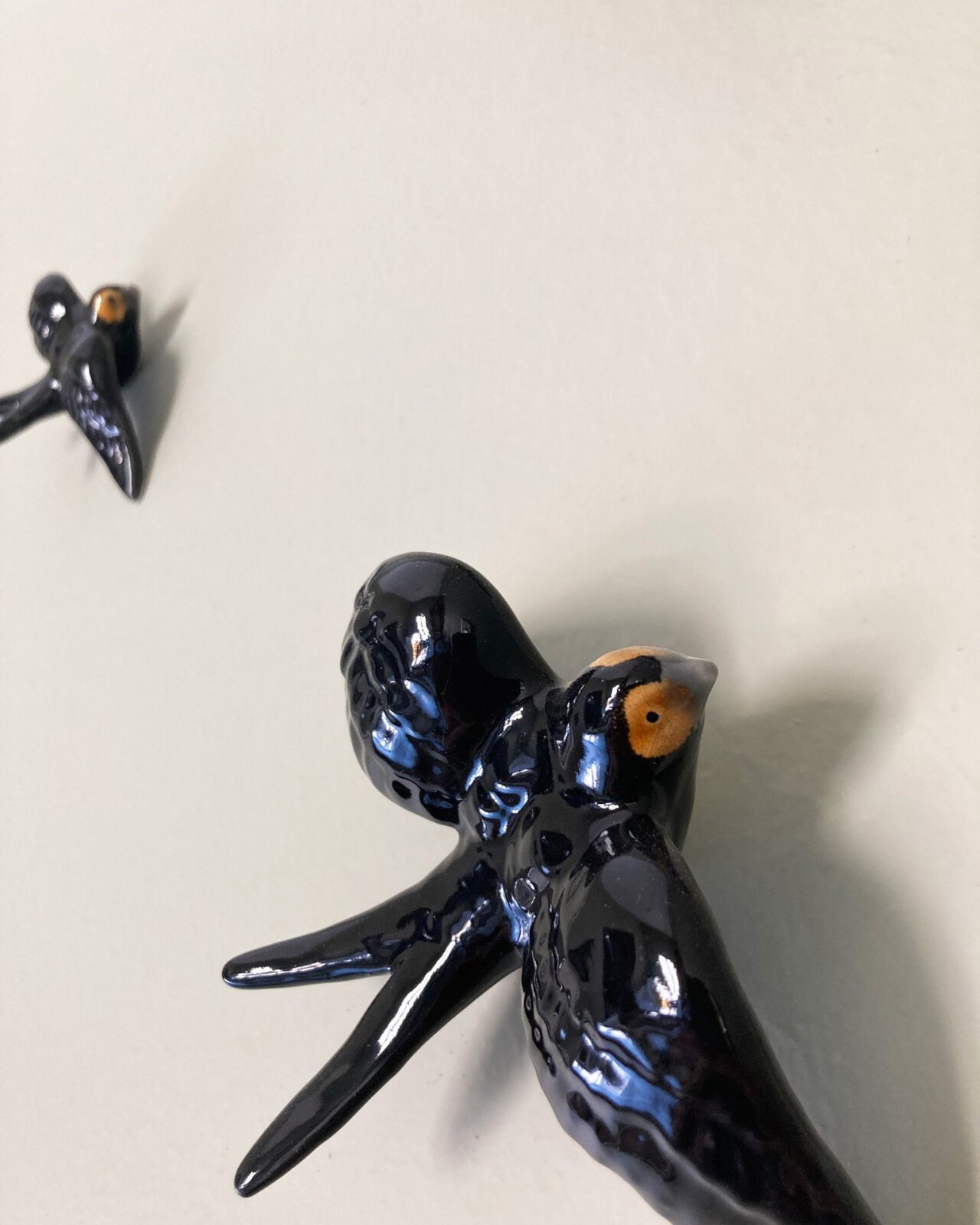 Two china birds on the wall.